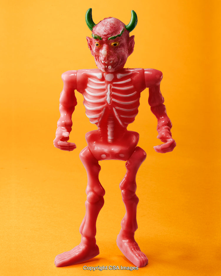 Red Plastic Toy Skeleton with Devil Horns in Bright Background