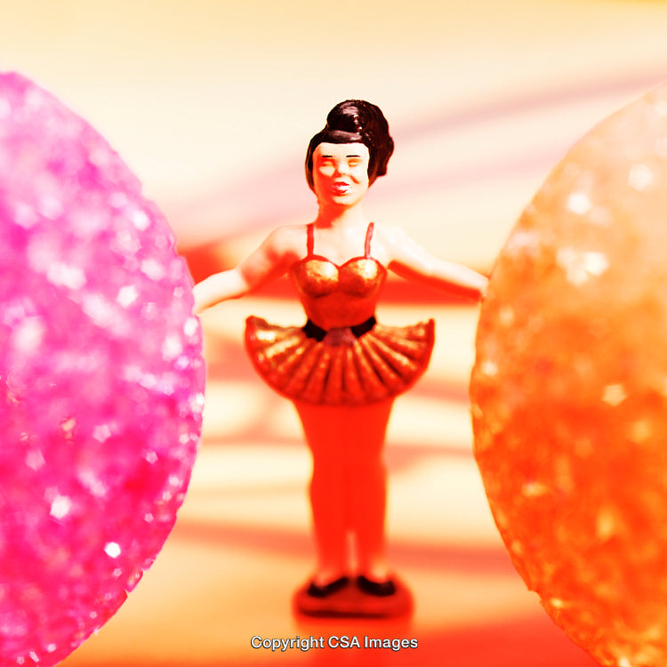 Close-Up of a Colorful Plastic Ballerina Figurine Surrounded by Vibrant Bright Spheres