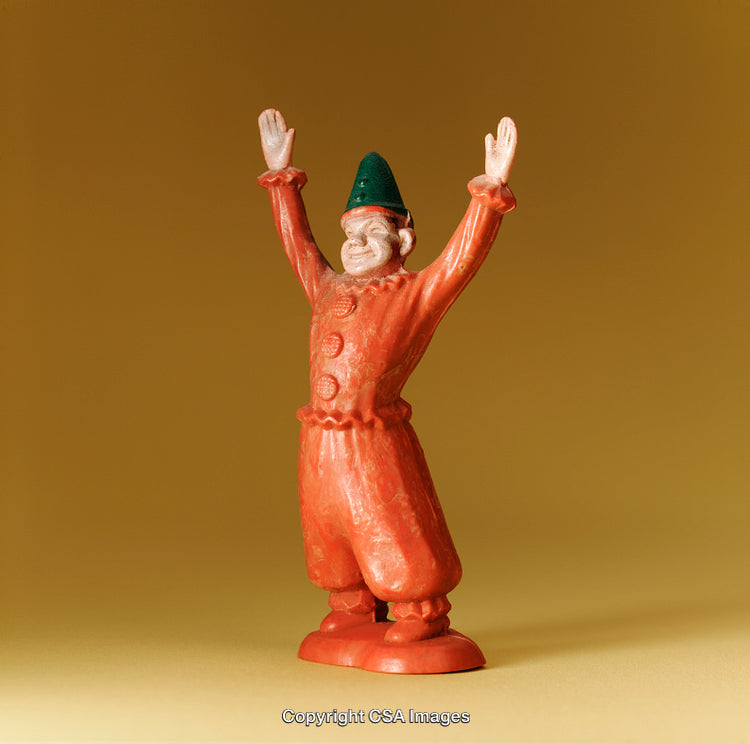 Colorful Toy Figure Dressed in Festive Attire with Raised Arms