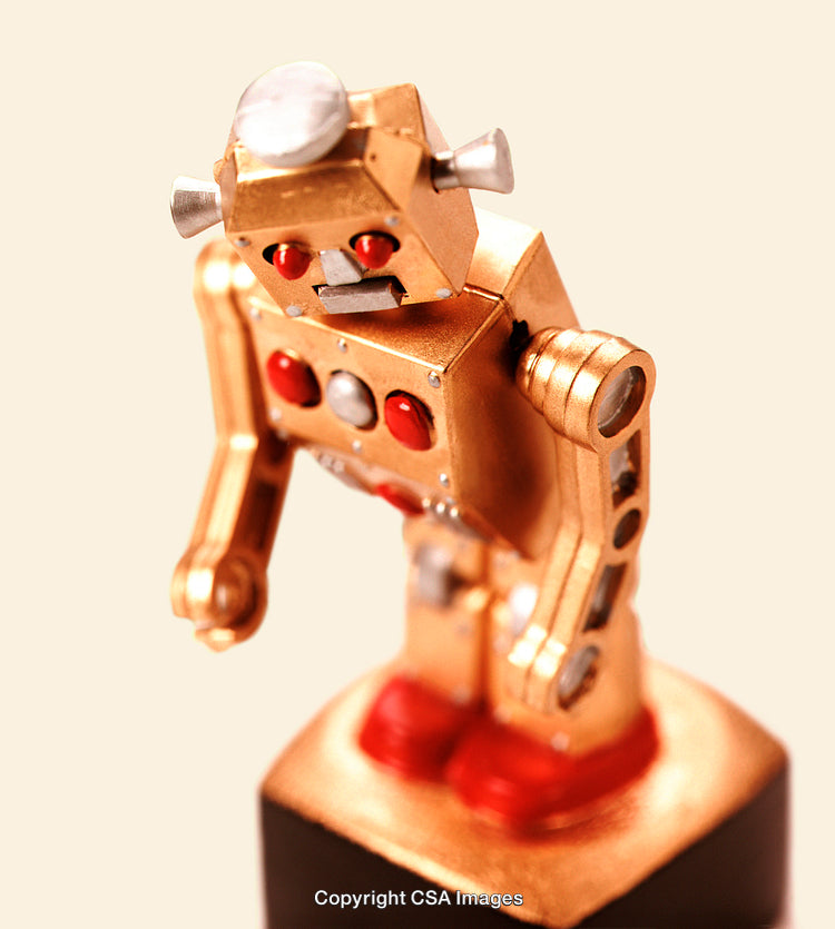 Vintage Robot Toy in Gold with Red Accents on a Neutral Background