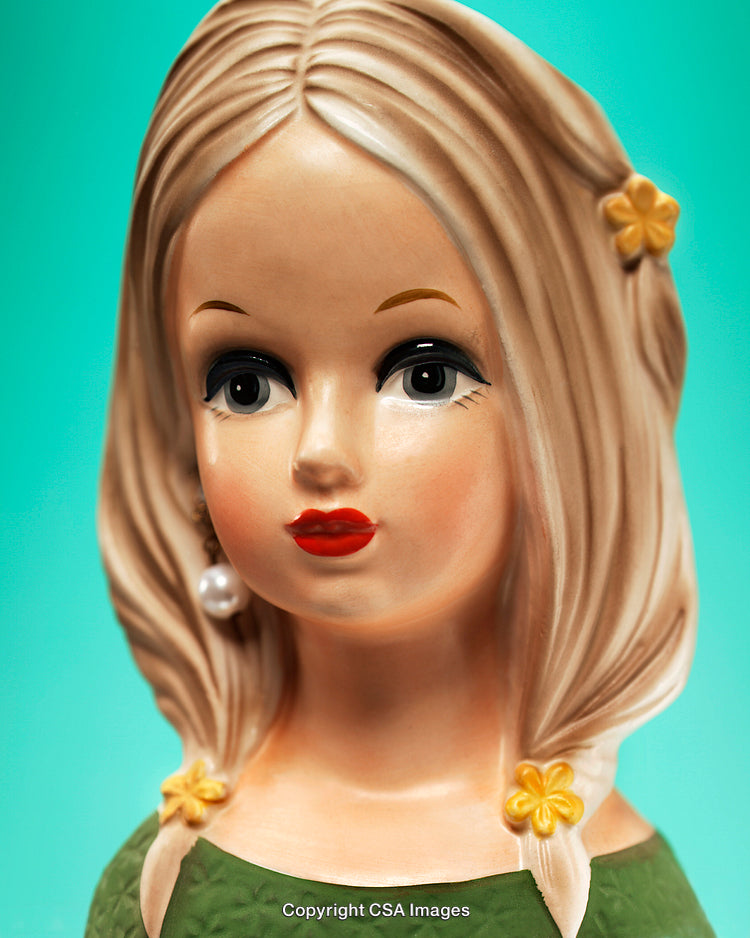 Portrait of a Stylish Figurine with Blonde Hair Against Aqua Background