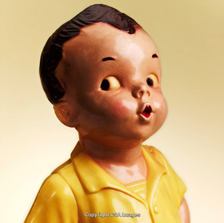 Vintage Figurine of a Child in Yellow with Expressive Facial Features