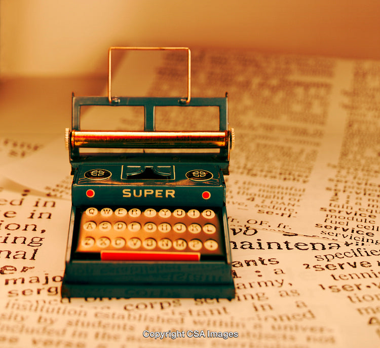 Vintage Toy Typewriter on a Textured Printed Paper Surface