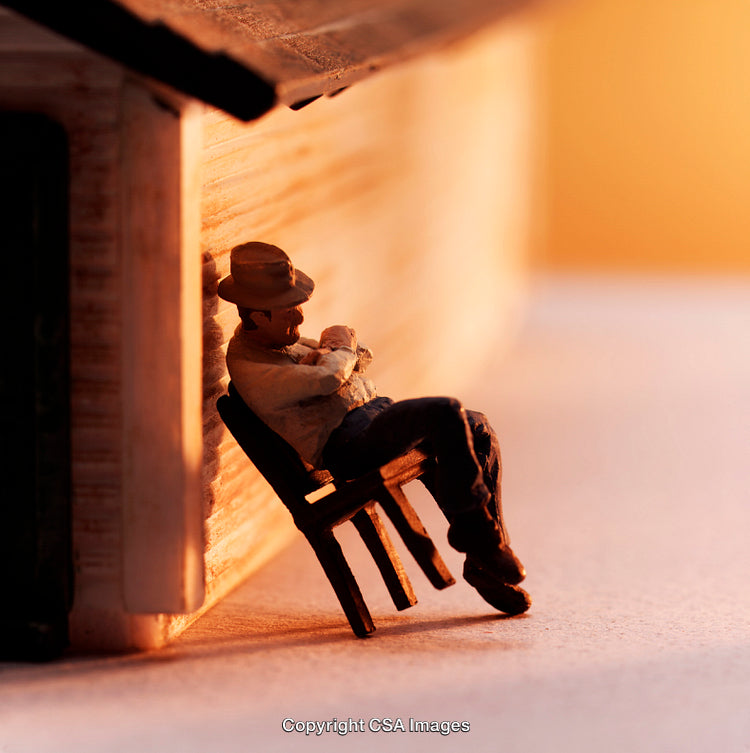 Miniature Figure Relaxing Against a Wall During Sunset
