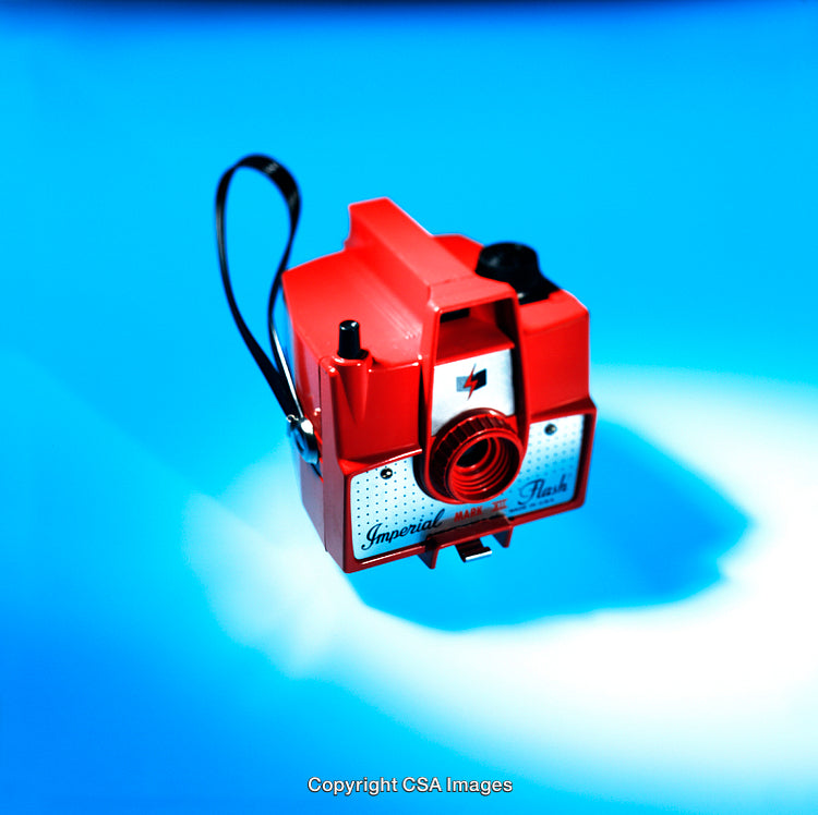 Vintage Red Plastic Camera Toy on a Vibrant Blue Background