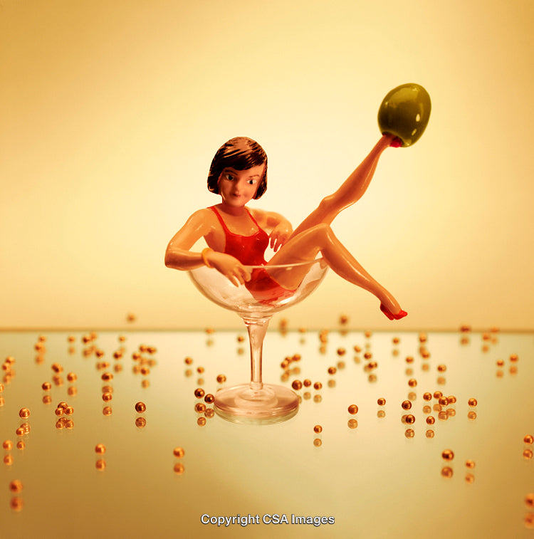 Miniature Figure in Cocktail Glass with Playful Beads and Golden Light