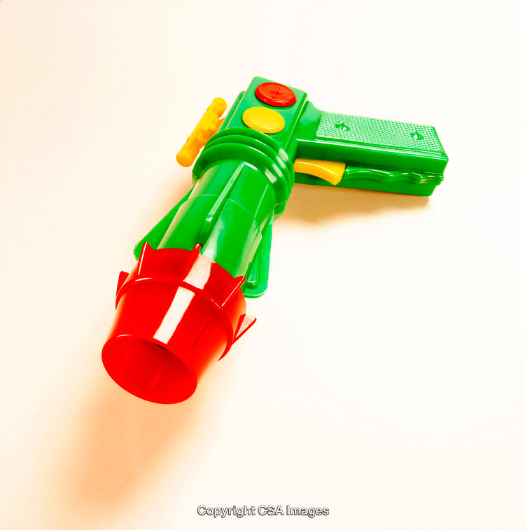 Green and Red Plastic Toy Gun on a Light Background