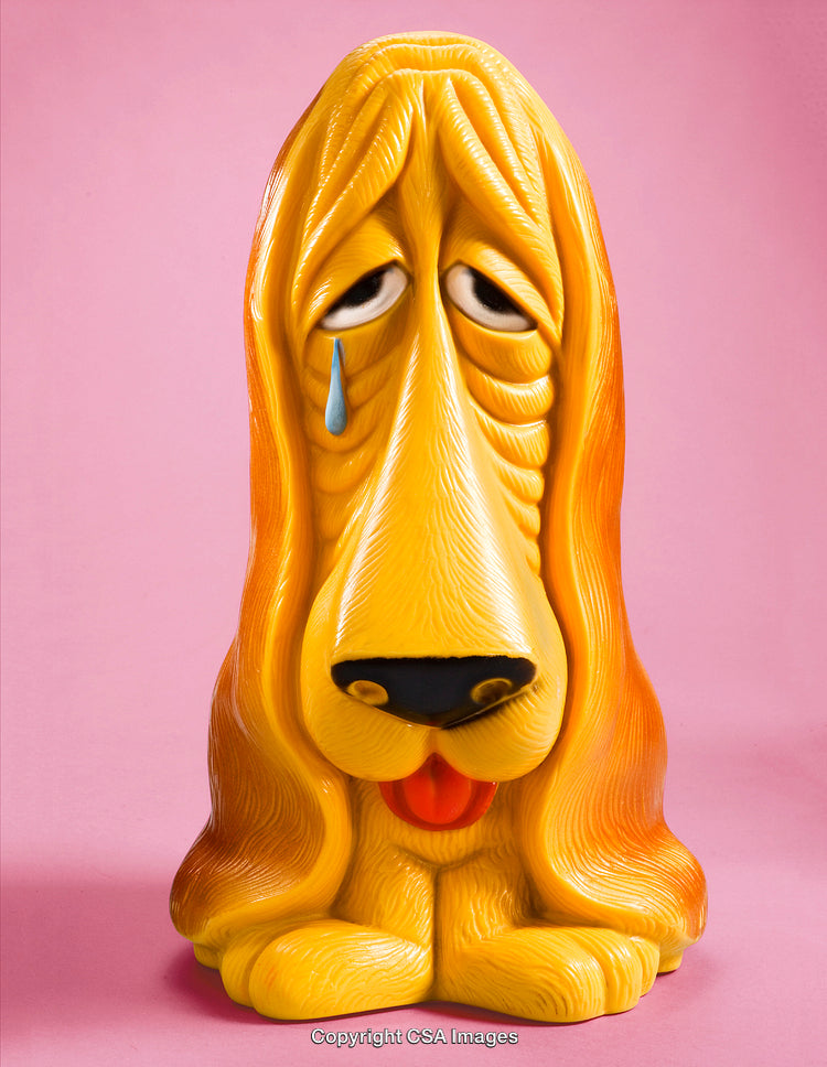 Colorful Dog Figurine with Sad Expression and Pink Background
