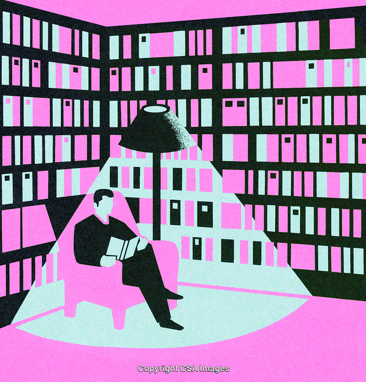 Man Reading a Book in a Modern Library Lit by a Spotlight