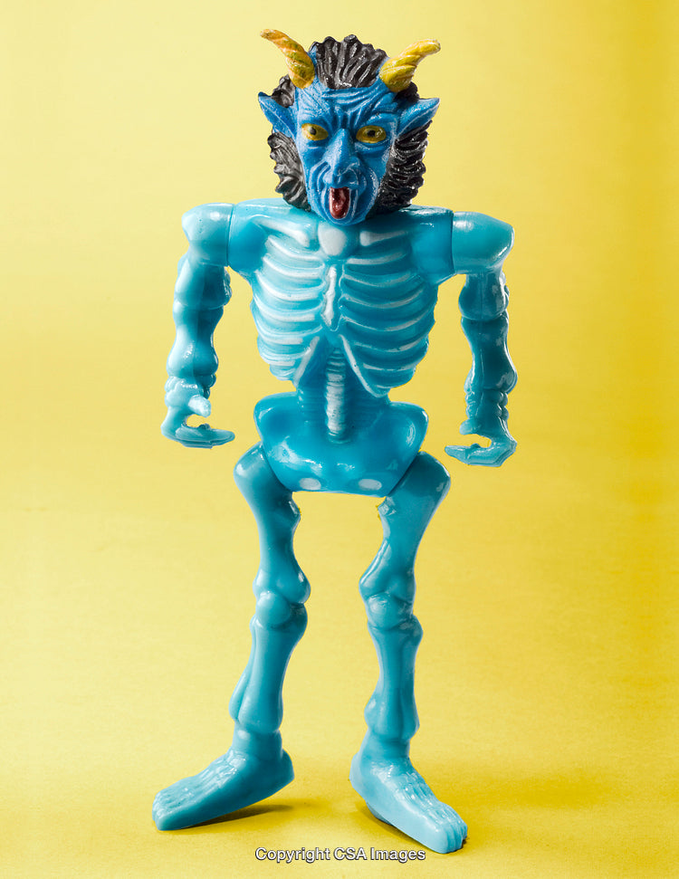 Blue Horned Demon Toy Figure on Yellow Background in Studio Lighting