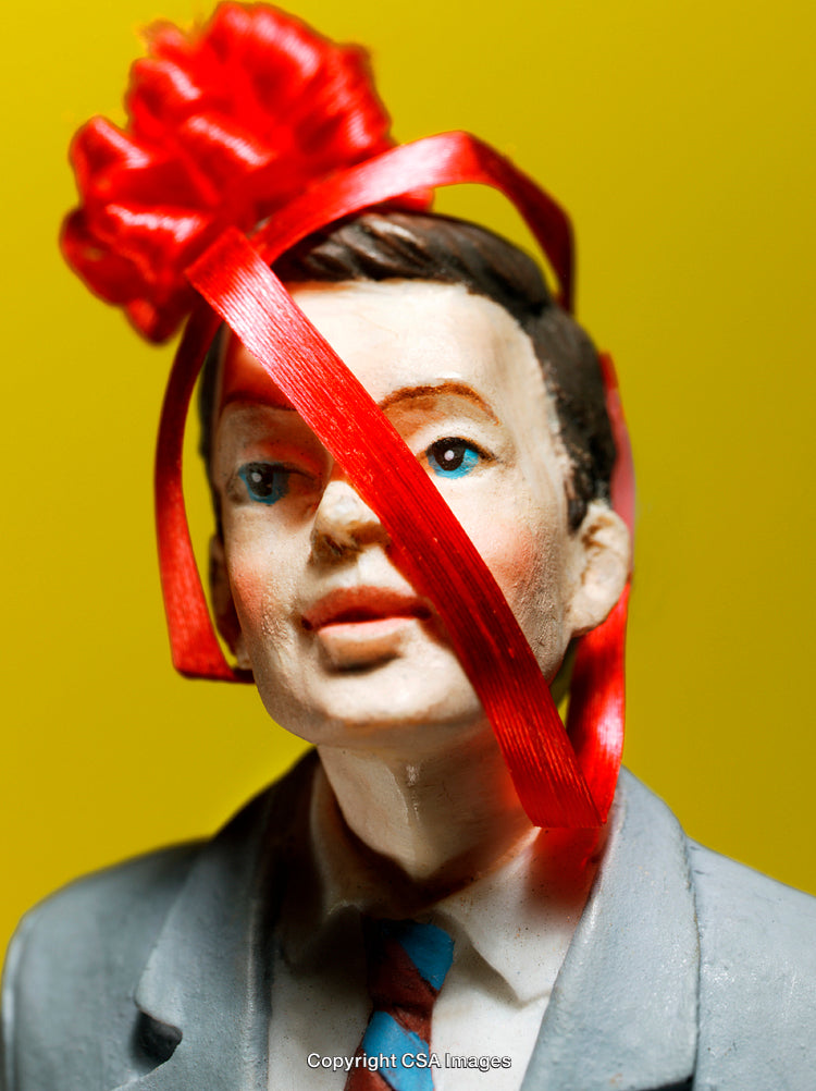 Close-Up of a Figurine with Creative Red Ribbon Decoration