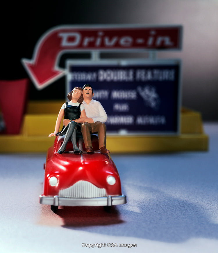 Miniature Romantic Figures on Red Car at Drive-In Theater
