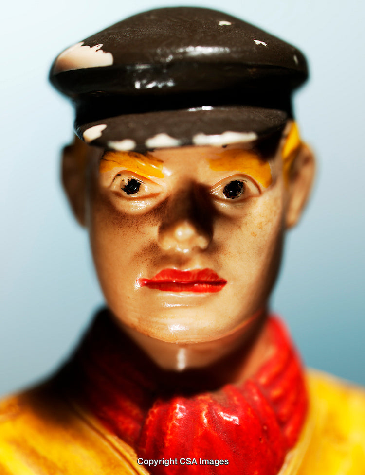 Close-Up of Painted Plastic Figurine with Hat and Red Scarf