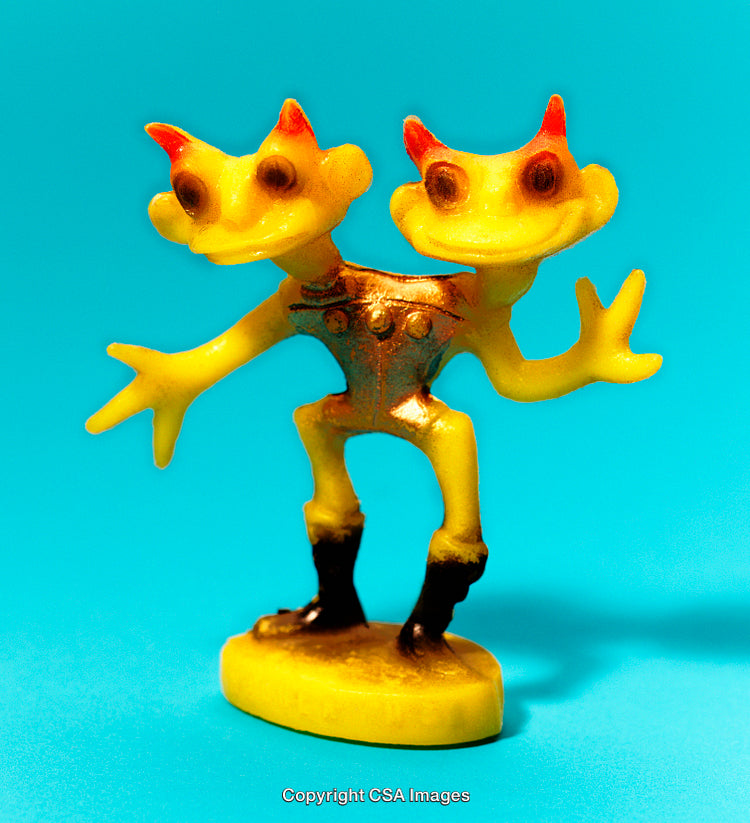 Yellow Two-Headed Figurine Isolated on Vibrant Blue Background
