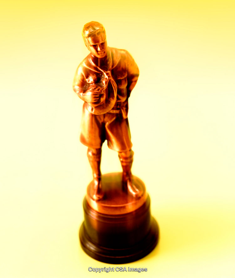 Bronze-Colored Plastic Figurine Depicting a Baseball Player on Yellow Background