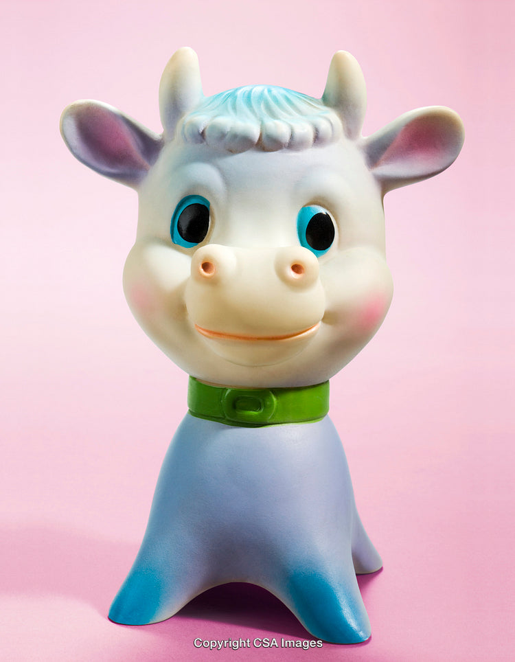 Colorful Plastic Cow Toy Over Pink Background Displaying Fun and Playful Design