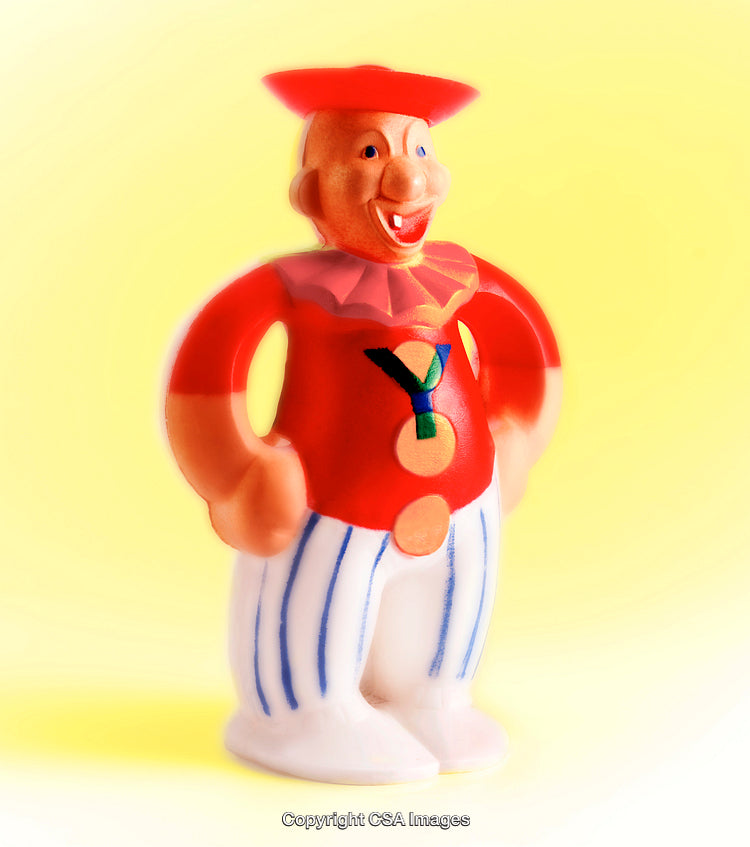 Colorful Plastic Figurine of a Smiling Character on a Yellow Background