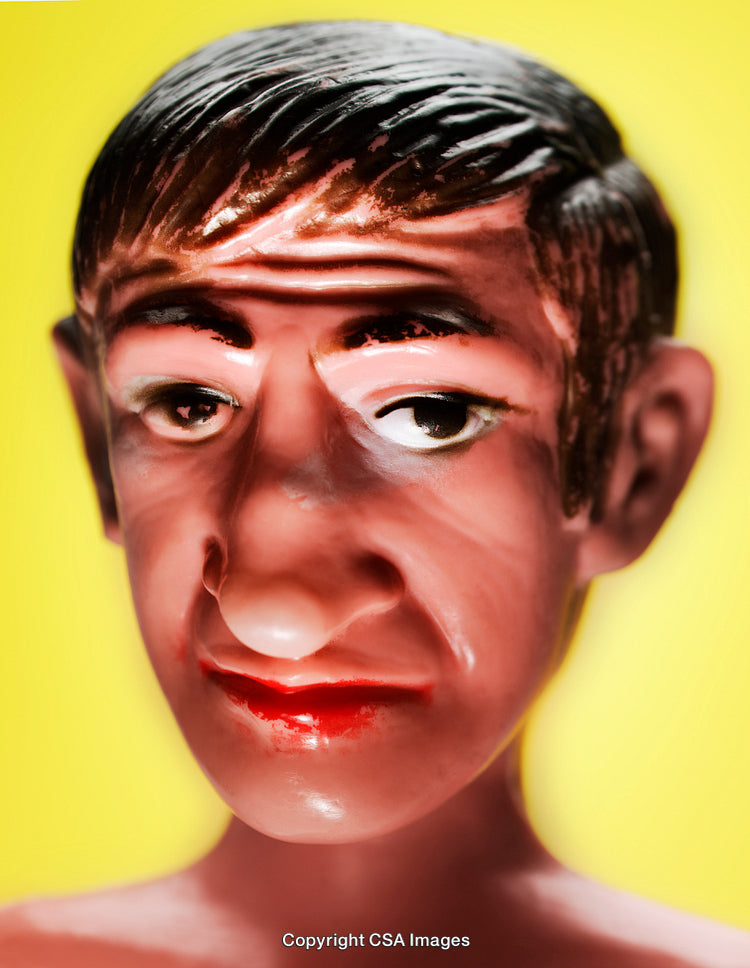 Close-Up of a Sculpted Plastic Face with Yellow Background
