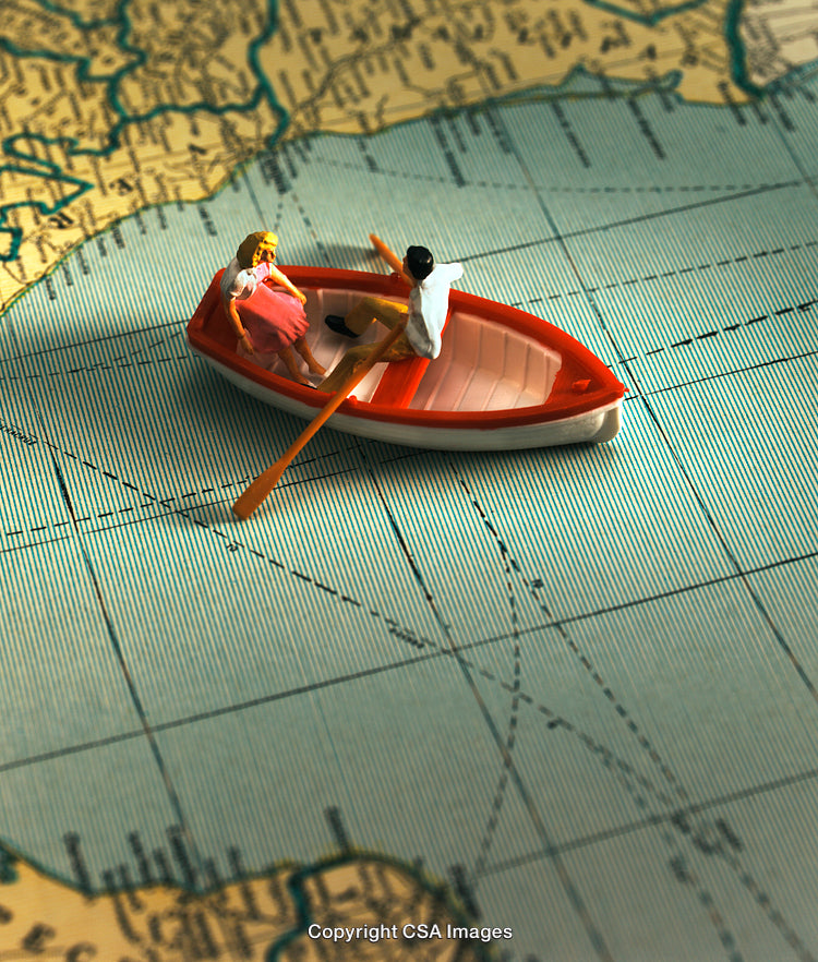 Miniature Rowboat Figurines on a Map Representing Travel and Adventure
