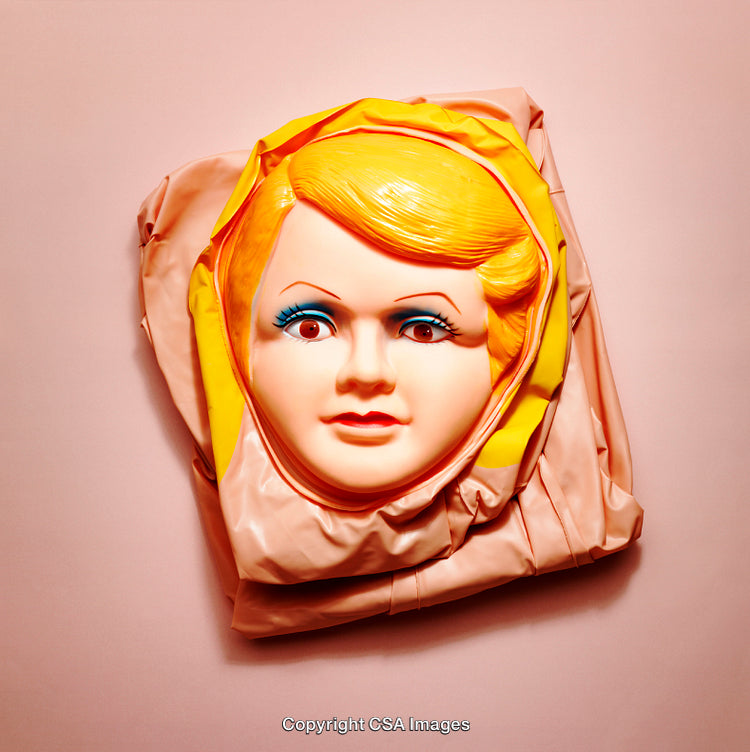 Bright Vintage-Style Plastic Doll Mask Against a Pink Background