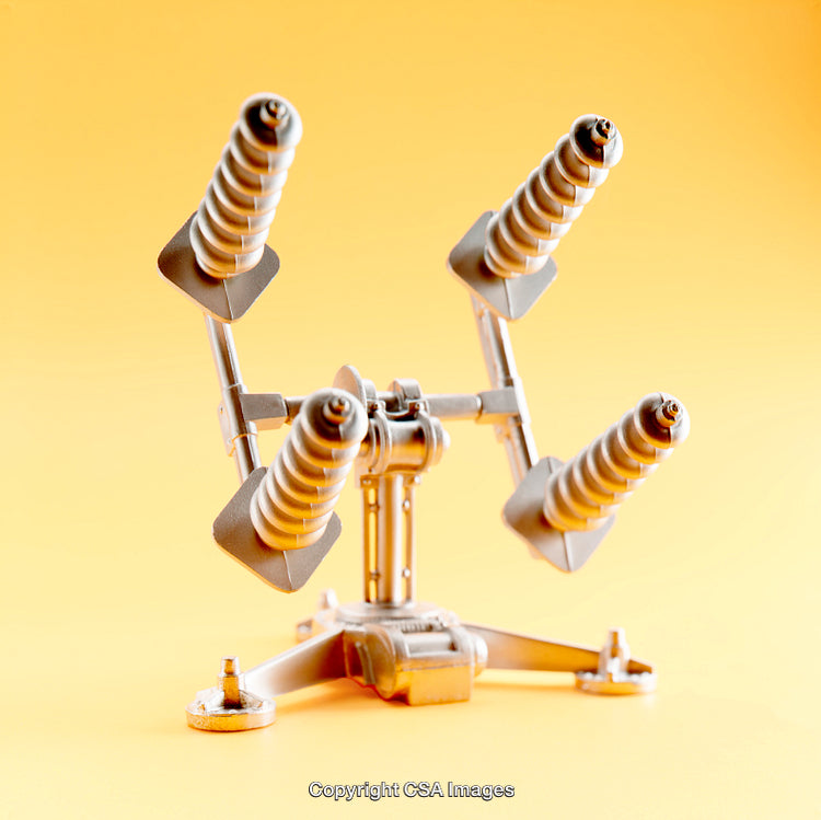 Silver Toy Machine Model on Solid Yellow Background Highlighting Details