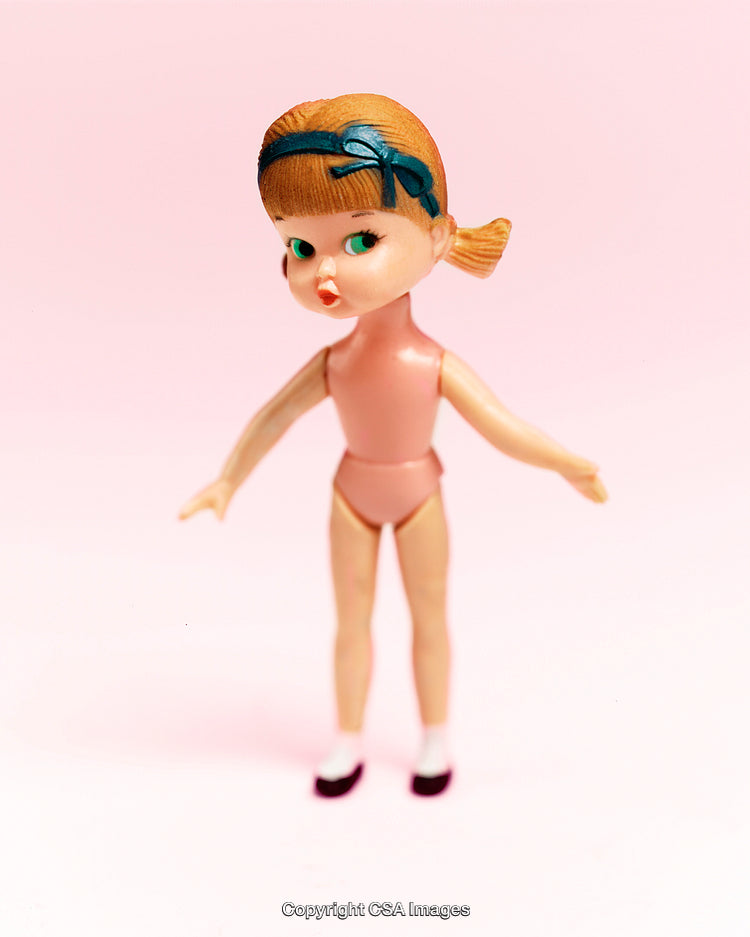 Vintage Plastic Doll Toy On a Pink Background