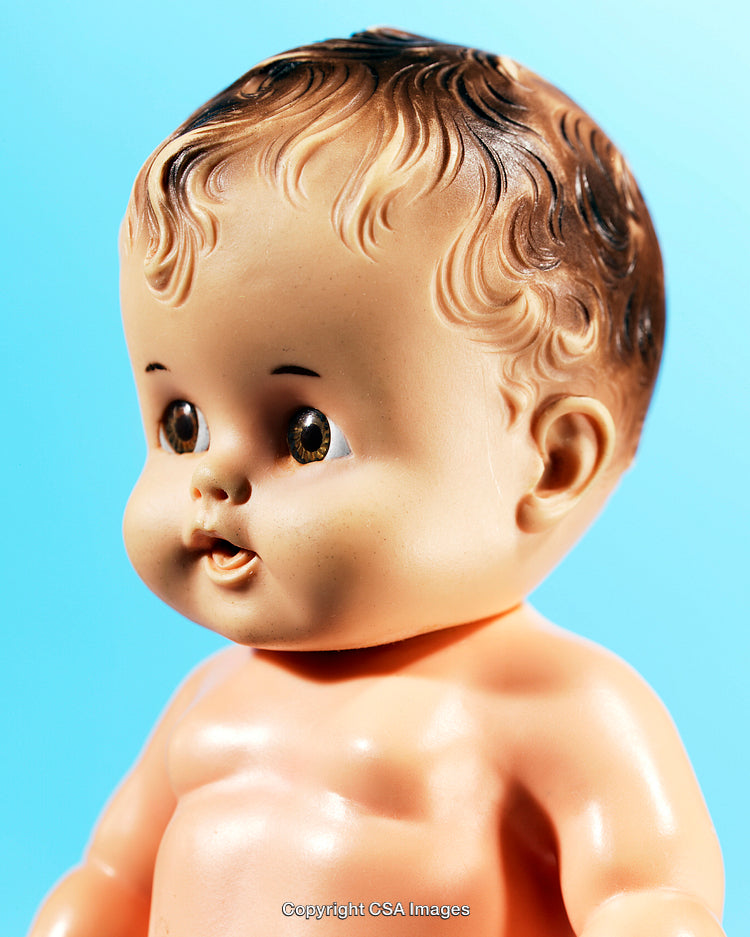 Close-Up of a Vintage Baby Doll Against Light Blue Background