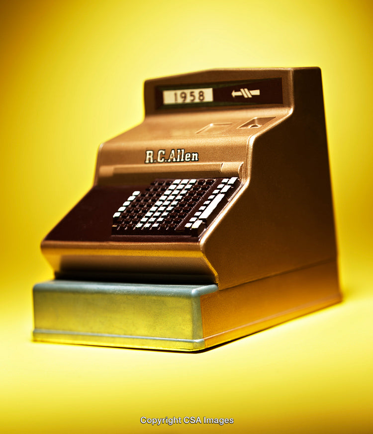 Retro Toy Cash Register Against Bright Yellow Background