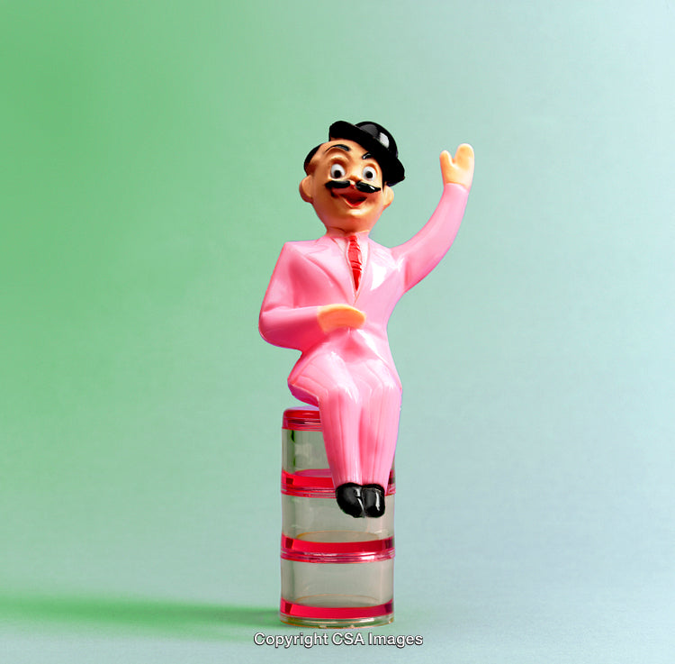 Colorful Plastic Figurine Sitting on a Decorative Surface with Green Background