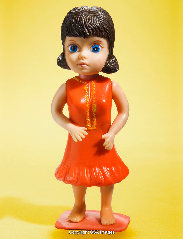 Retro Plastic Girl Figurine with Blue Eyes on Yellow Background