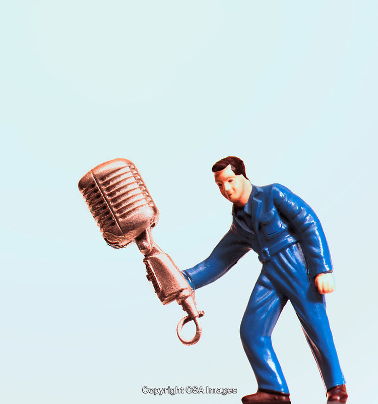 Stylized Plastic Toy Figure Holding Large Microphone on Blue Background