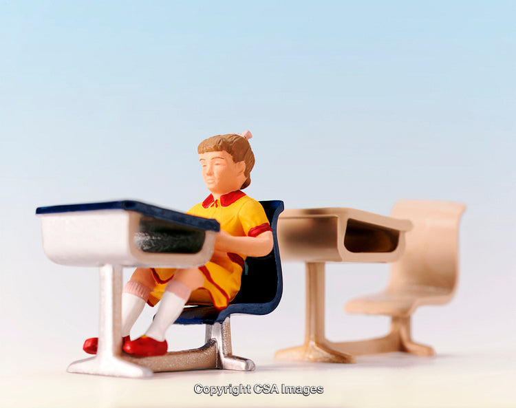 Miniature Toy Student Seated at Desk in Classroom Setting