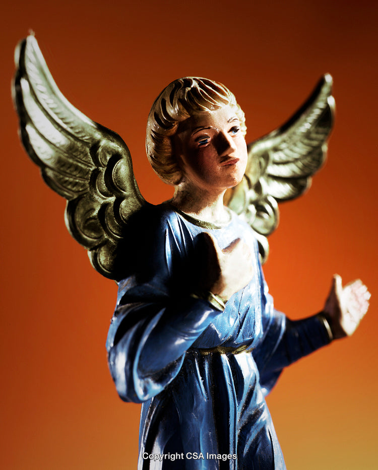 Close-Up of Angel Figurine with Golden Wings and Blue Robe on Orange Background