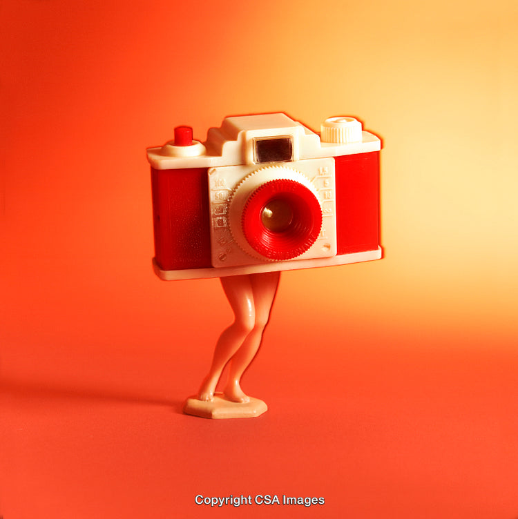 Surreal Toy Camera with Legs Against Red-Orange Backdrop