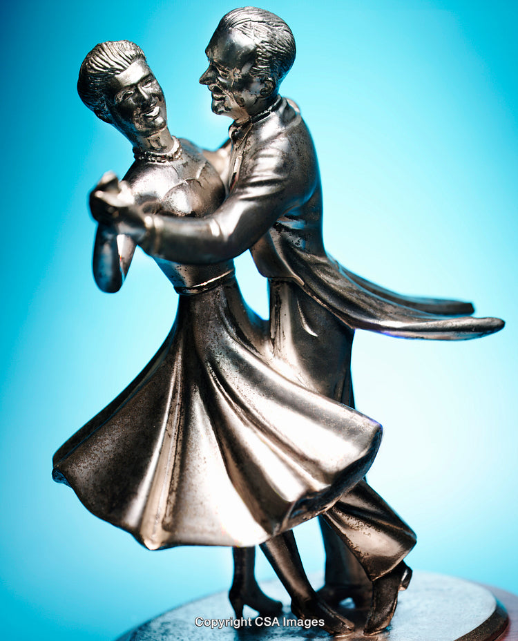 Silver-Toned Dancing Figurine Capturing Elegance on a Blue Background
