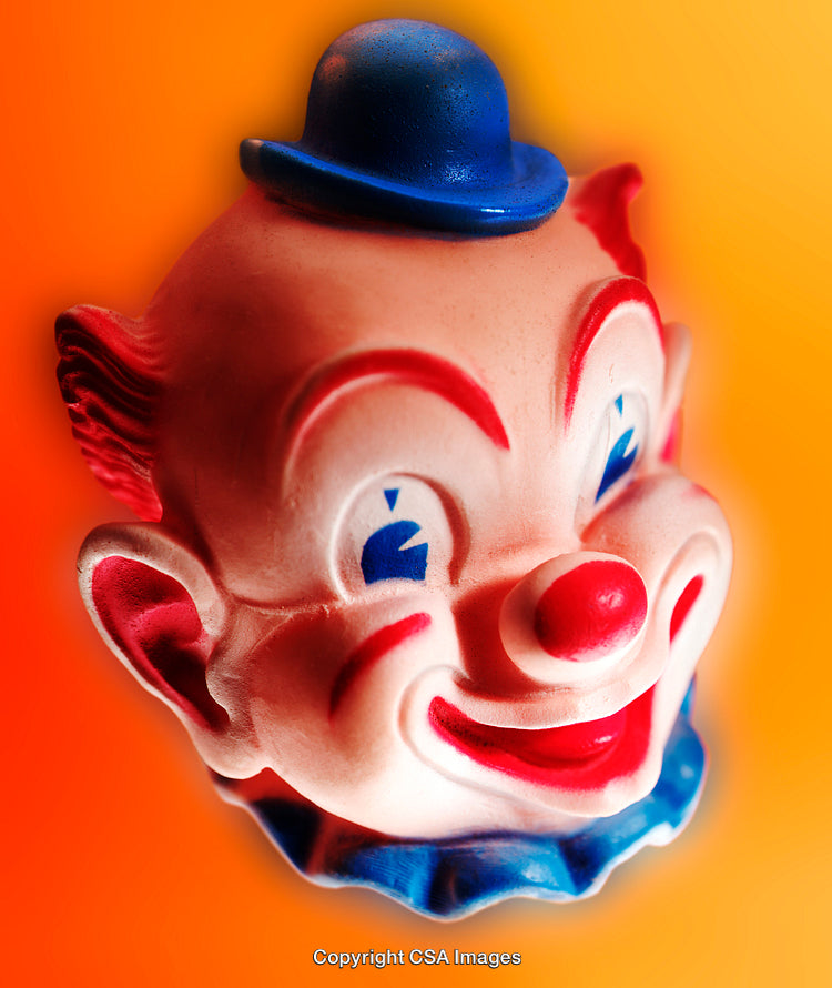Close-Up of a Vibrant Plastic Clown Toy on Orange Background