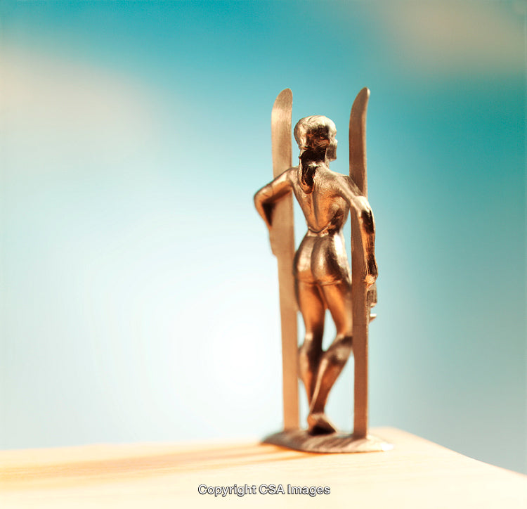 Golden Figurine of Skier Against Vibrant Blue Background