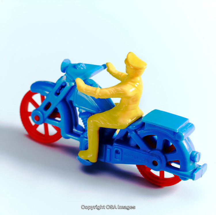 Colorful Plastic Toy Motorcycle with Rider on a Light Background