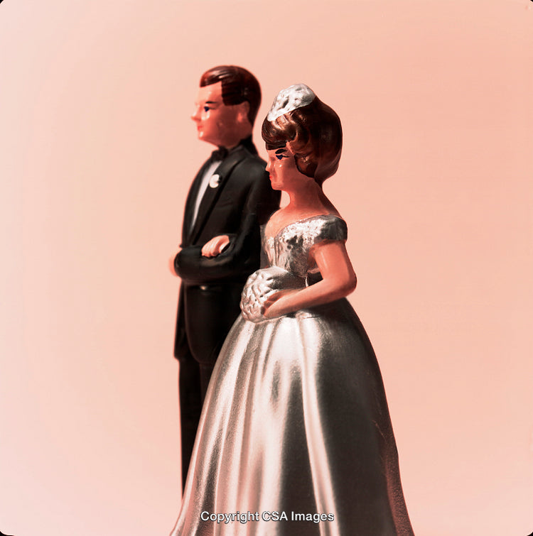 Classic Bride and Groom Figurines Against a Soft Pink Background
