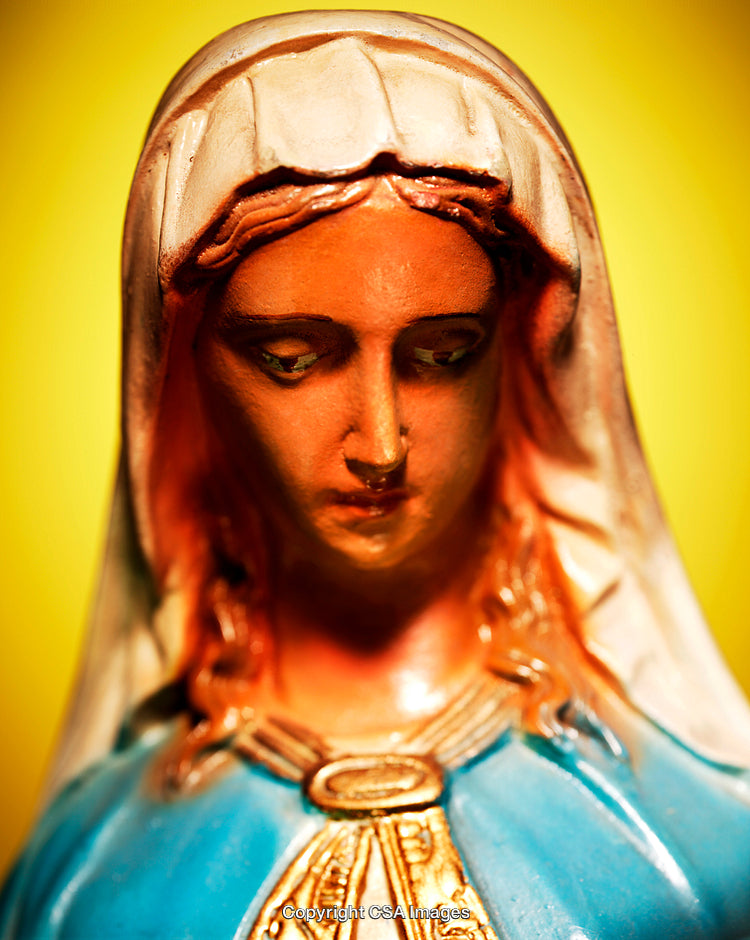 Close-Up of a Painted Religious Figurine with a Vibrant Yellow Background
