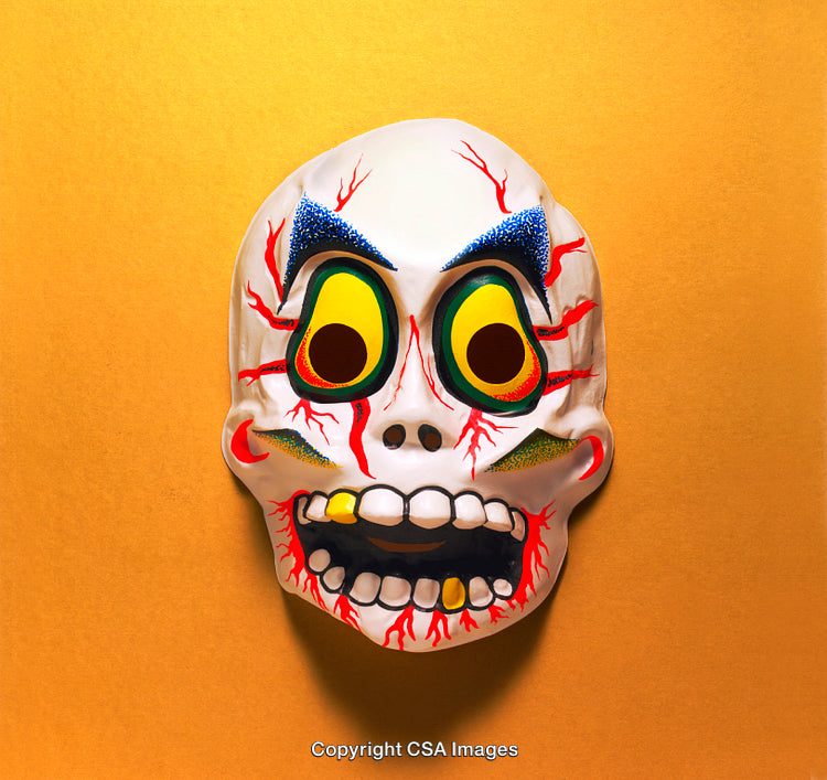 Colorful Plastic Halloween Skull Mask With Spooky Details on Orange Background