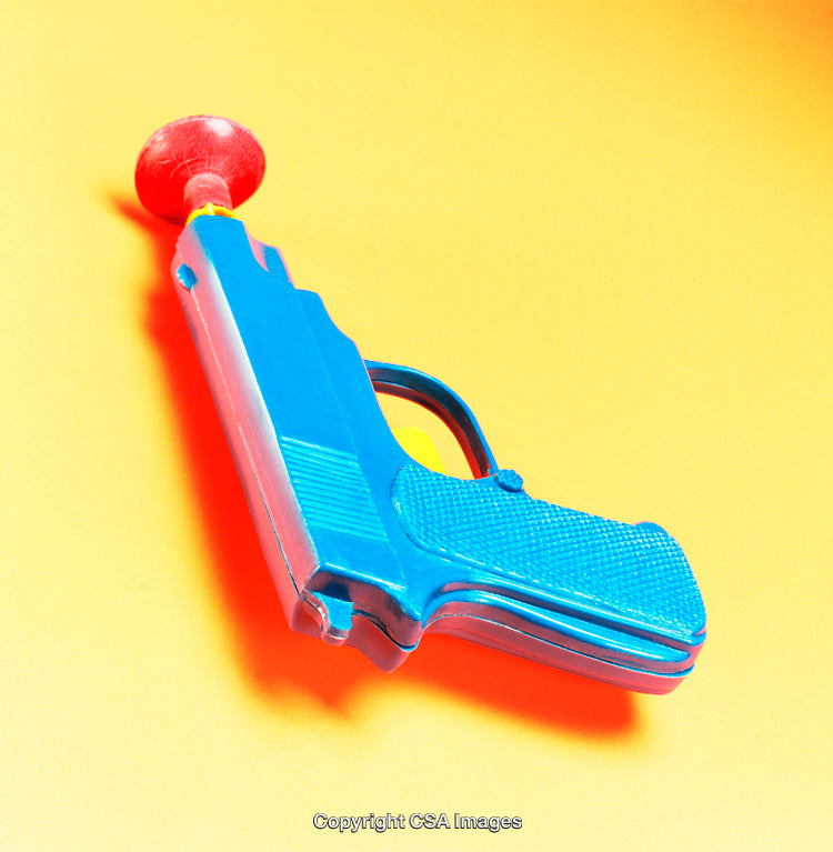 Blue Plastic Toy Gun With a Red Suction Tip on a Yellow Background