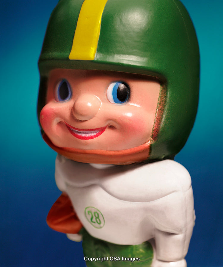 Close-Up of a Smiling Retro Football Toy Figurine on Blue Background