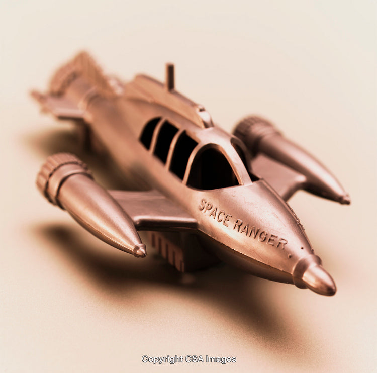 Retro Styled Metallic Space Ranger Toy Rocket on Neutral Background