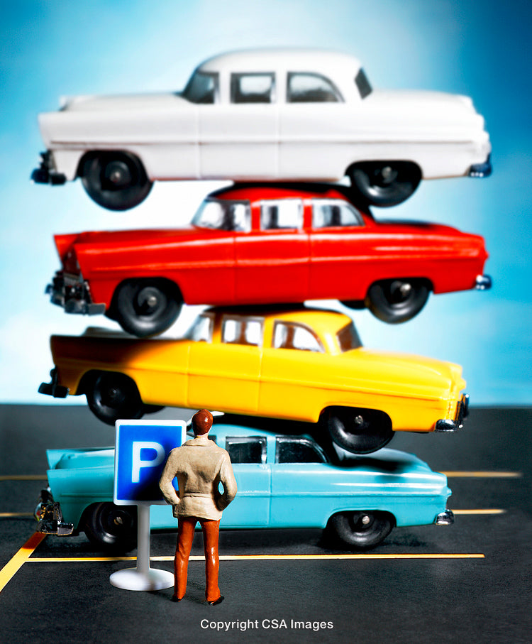 Miniature Figure Observing Stacked Vintage Toy Cars in Parking Lot Scene