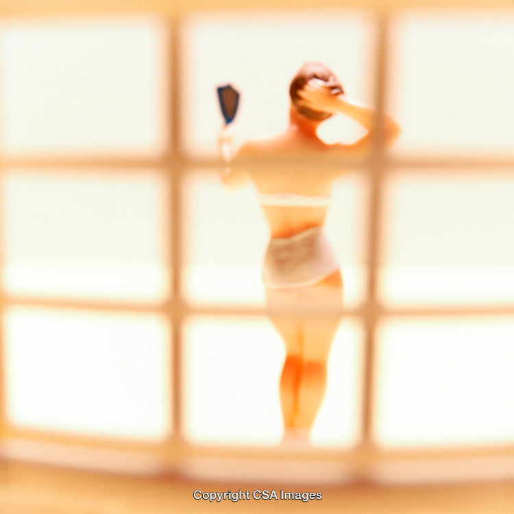 Plastic Figurine of Woman Holding Mirror in Blurred Perspective