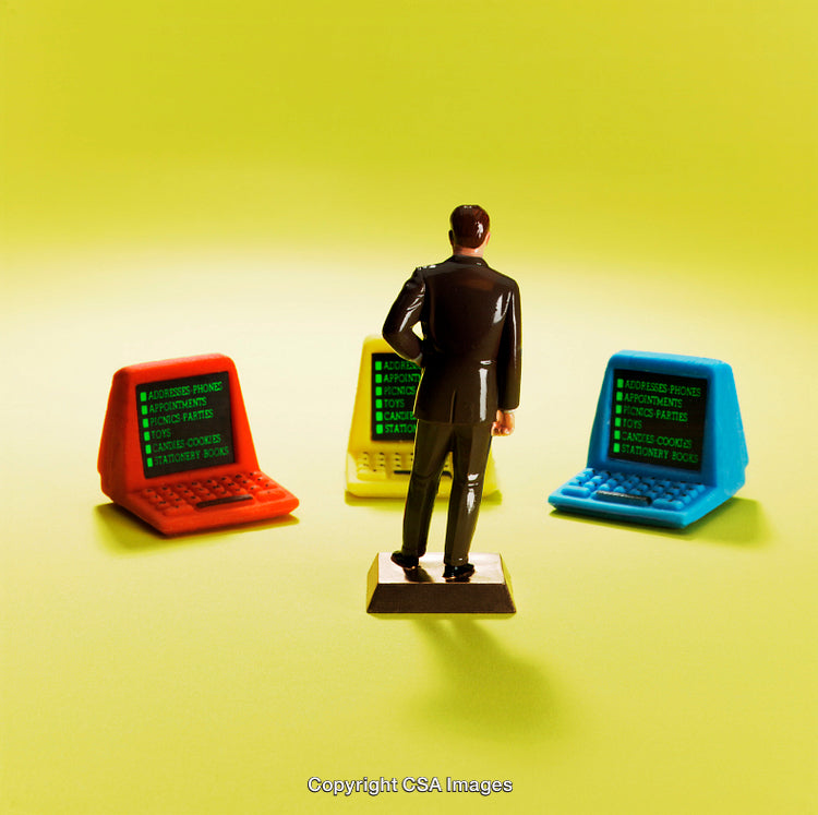 Plastic Toy Businessman Facing Colorful Laptops Representing Decision Making and Choices