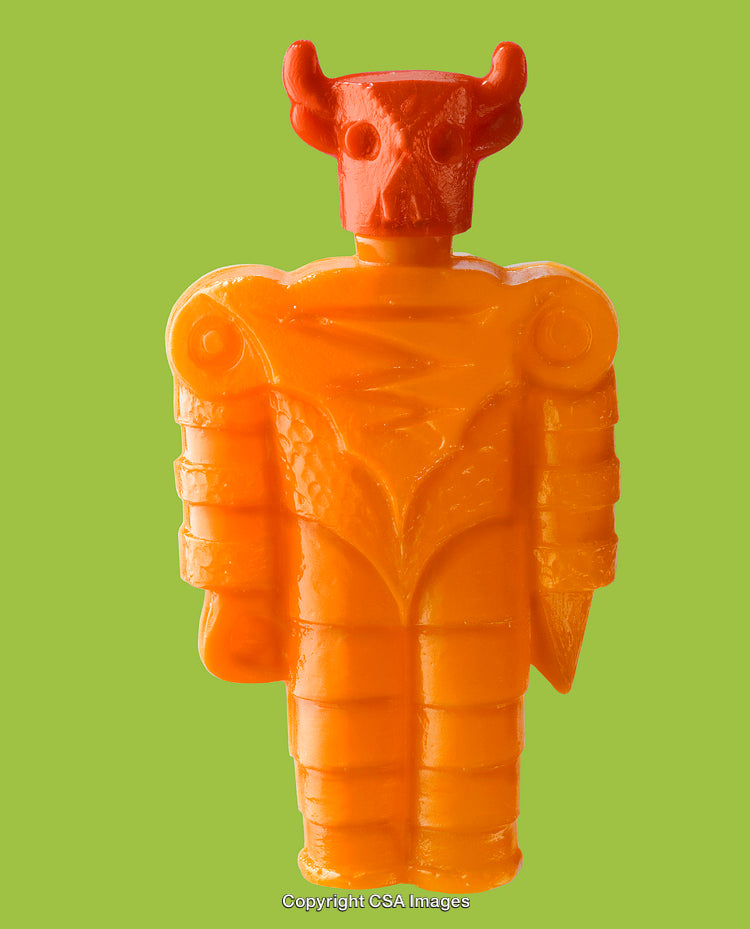 Bright Orange Toy Figure With Mask and Horns on Green Background