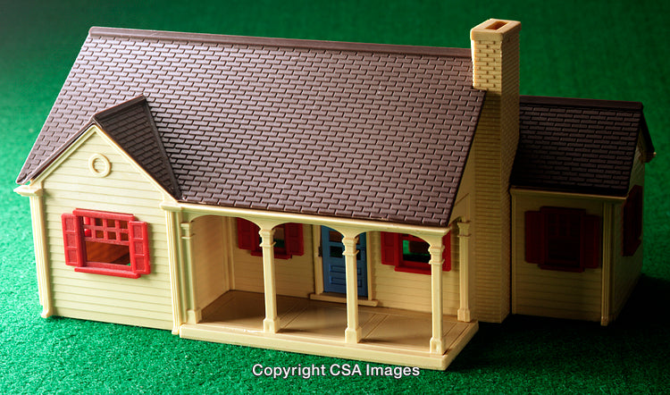 Miniature House Model on Green Background Representing a Toy or Display Concept