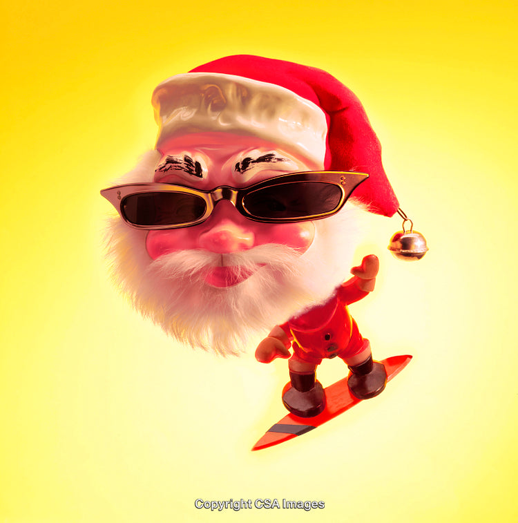 Santa Claus Figurine Surfing with Festive Sunglasses Against Yellow Background